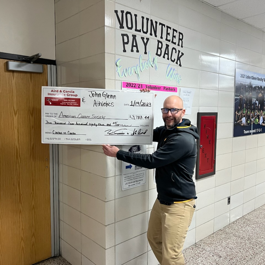 Teacher holding up check